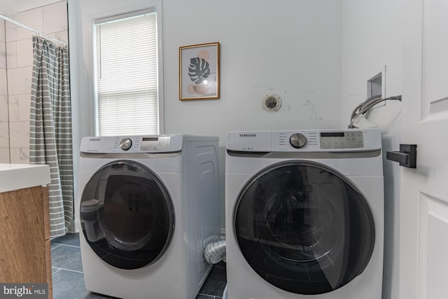 clothes washing area featuring washer and dryer and tile patterned floors