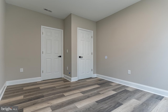 unfurnished bedroom featuring wood finished floors and baseboards