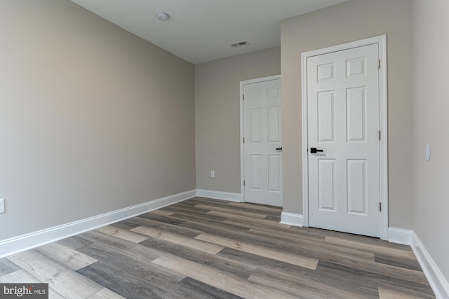 unfurnished bedroom featuring wood finished floors and baseboards