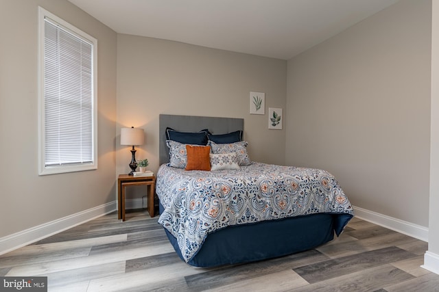 bedroom featuring wood finished floors and baseboards