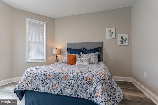 bedroom featuring wood finished floors and baseboards