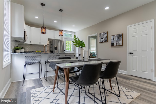 dining space featuring light wood-style floors, baseboards, and recessed lighting