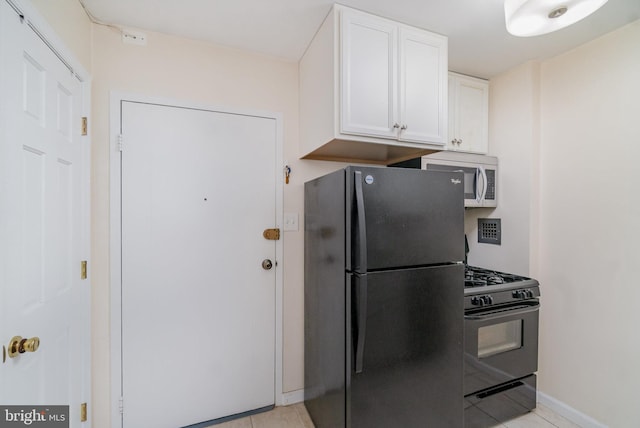 922 24th St NW Unit 419, Washington, DC 20037 - kitchen with black appliances, white cabinets, and light tile patterned flooring