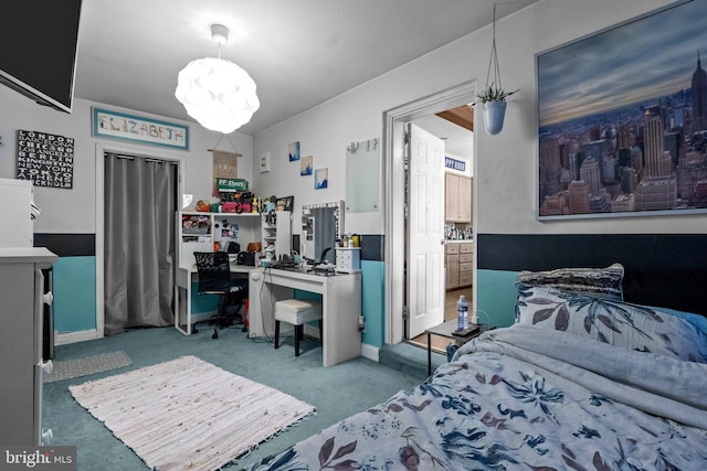carpeted bedroom featuring a desk and a chandelier