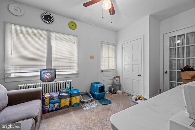 bedroom with radiator heating unit, carpet floors, and ceiling fan