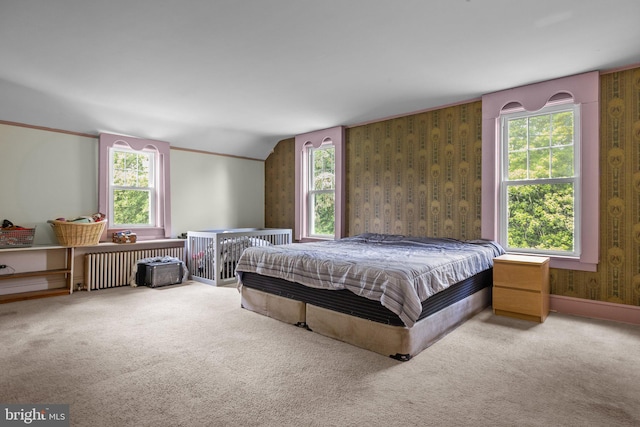 bedroom featuring radiator heating unit, carpet, and multiple windows