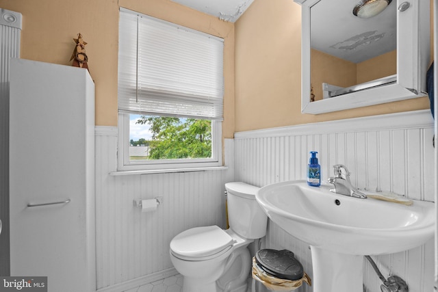 bathroom with a wainscoted wall and toilet