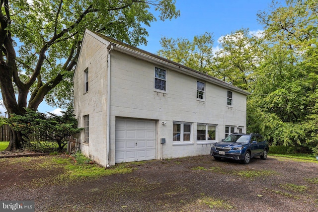view of front of house with a garage, driveway, and concrete block siding