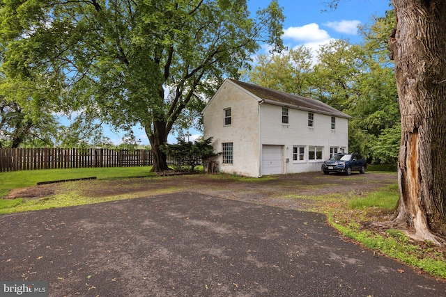 view of property exterior with fence and concrete block siding