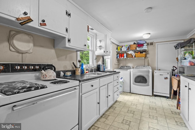 kitchen with white range with electric stovetop, a sink, independent washer and dryer, white cabinets, and brick patterned flooring