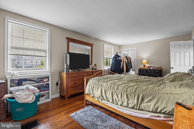 bedroom with a closet, wood finished floors, and baseboards