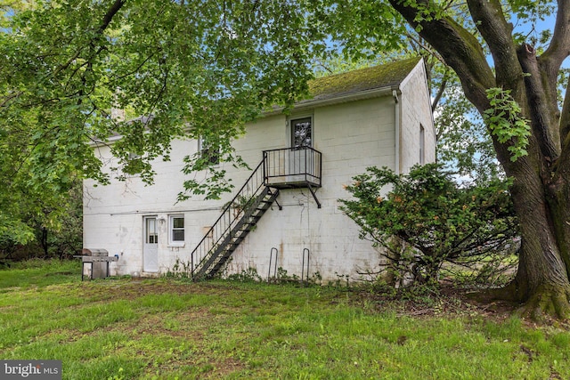 back of house with stairway and concrete block siding