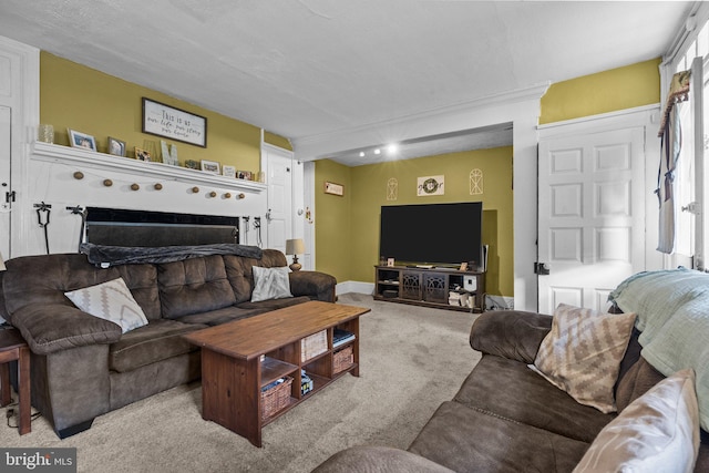 carpeted living area featuring baseboards