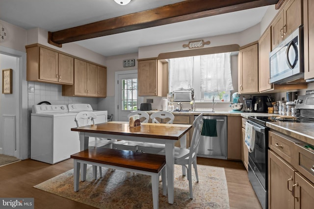 kitchen with stainless steel appliances, separate washer and dryer, beam ceiling, light wood-style flooring, and backsplash