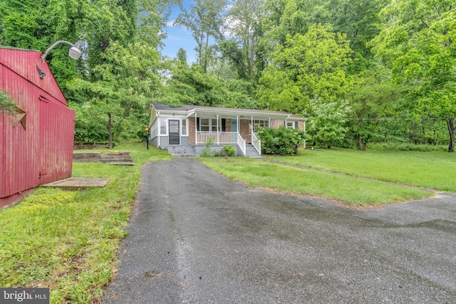 29823 Hillview Dr, Mechanicsville, MD 20659 - view of front facade featuring a porch, a front yard, brick siding, and asphalt driveway
