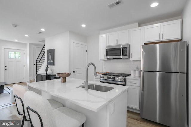 1456 Congress Pl SE, Washington, DC 20020 - kitchen with stainless steel appliances, a sink, wood finished floors, white cabinetry, and recessed lighting