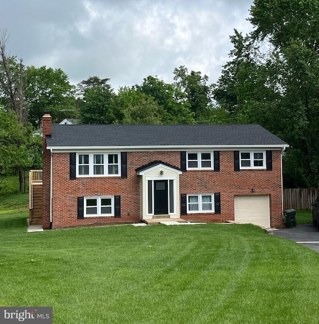 8601 Fort Dr, Manassas, VA 20110 - split foyer home featuring driveway, an attached garage, a chimney, brick siding, and view of wooded area