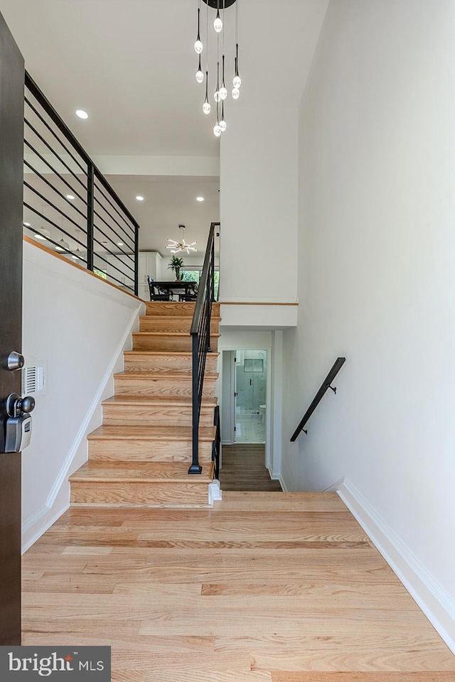 8601 Fort Dr, Manassas, VA 20110 - stairway featuring wood finished floors, baseboards, recessed lighting, and a chandelier