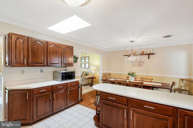 14600 Barton Blvd SW, Cresaptown, MD 21502 - kitchen featuring stainless steel microwave, light countertops, a skylight, light flooring, and crown molding