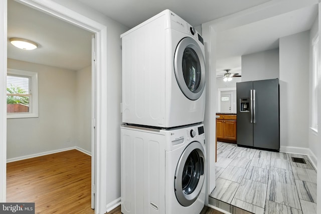 1208 Larchmont Ave, Capitol Heights, MD 20743 - laundry area with stacked washer and clothes dryer, ceiling fan, baseboards, and light wood finished floors