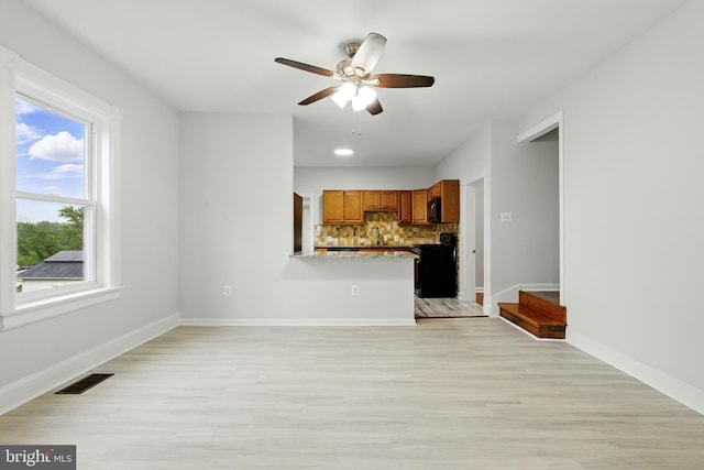 1208 Larchmont Ave, Capitol Heights, MD 20743 - unfurnished living room with a ceiling fan, light wood-style flooring, baseboards, and a sink