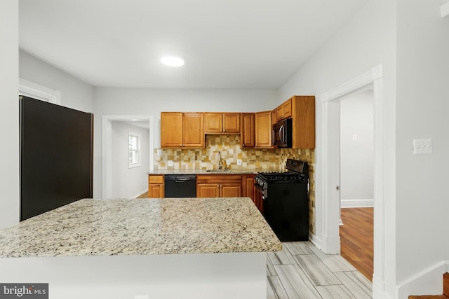 1208 Larchmont Ave, Capitol Heights, MD 20743 - kitchen with black appliances, a sink, light stone countertops, tasteful backsplash, and light wood finished floors