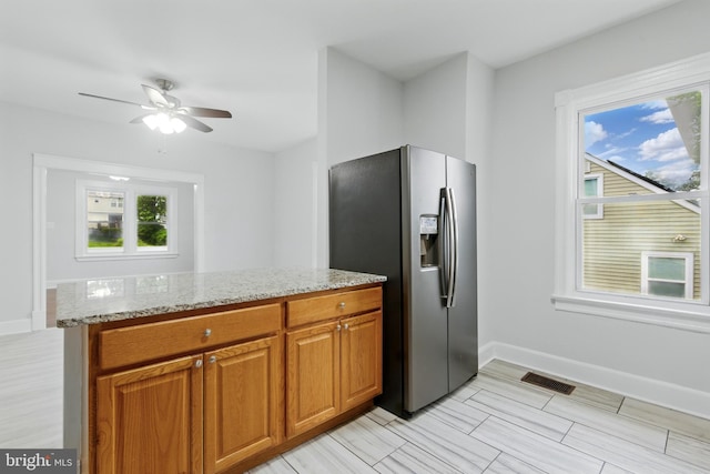 1208 Larchmont Ave, Capitol Heights, MD 20743 - kitchen featuring stainless steel fridge, light stone counters, a ceiling fan, and brown cabinets