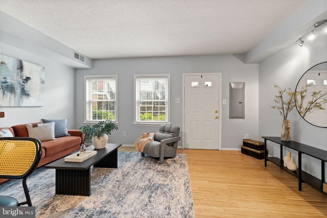 122 N Bedford St Unit A, Arlington, VA 22201 - living room with light wood-style floors, a textured ceiling, electric panel, and baseboards