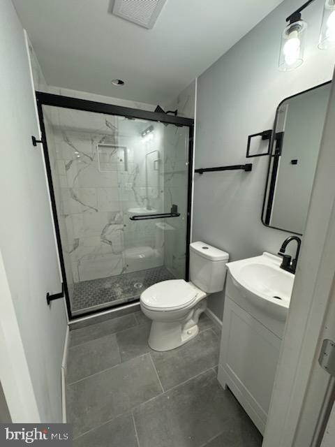 5303 55th Pl, Riverdale, MD 20737 - bathroom with toilet, a marble finish shower, vanity, and baseboards