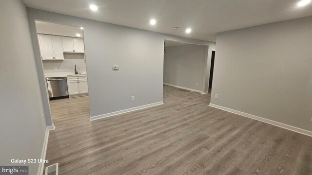 5303 55th Pl, Riverdale, MD 20737 - unfurnished living room featuring recessed lighting, light wood-style flooring, baseboards, and a sink