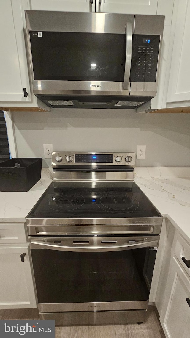 5303 55th Pl, Riverdale, MD 20737 - kitchen view of appliances with stainless steel finishes, white cabinets, and light stone counters