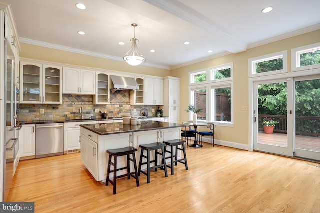 2739 Chesapeake St NW, Washington, DC 20008 - kitchen featuring stainless steel dishwasher, a sink, wall chimney range hood, dark countertops, and a breakfast bar area