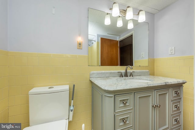 611 N Ct, Linthicum Heights, MD 21090 - bathroom featuring tile walls, wainscoting, vanity, and toilet