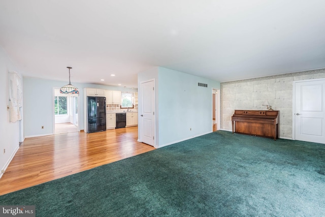 611 N Ct, Linthicum Heights, MD 21090 - unfurnished living room with baseboards, light carpet, light wood-type flooring, and recessed lighting