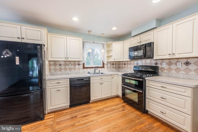 611 N Ct, Linthicum Heights, MD 21090 - kitchen featuring black appliances, a sink, light countertops, open shelves, and light wood-style floors