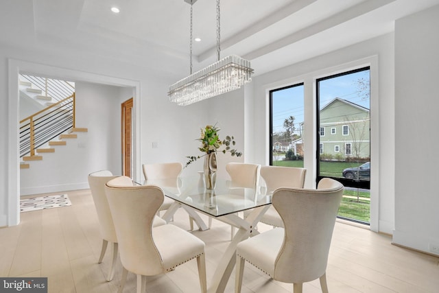 dining space featuring stairway, a chandelier, a raised ceiling, recessed lighting, and baseboards