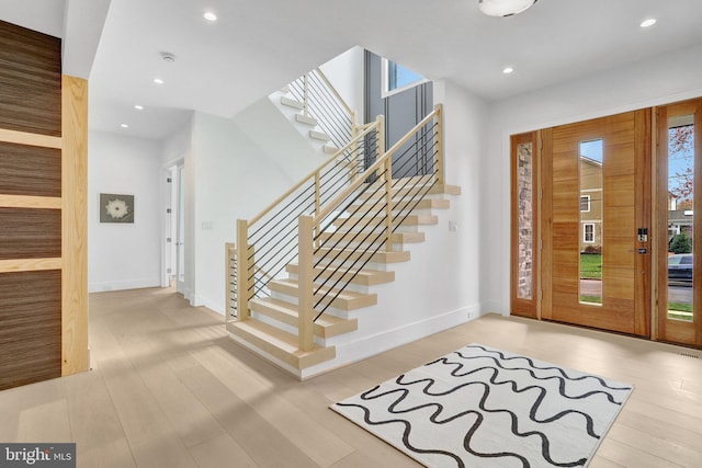entryway with stairway, wood finished floors, baseboards, and recessed lighting
