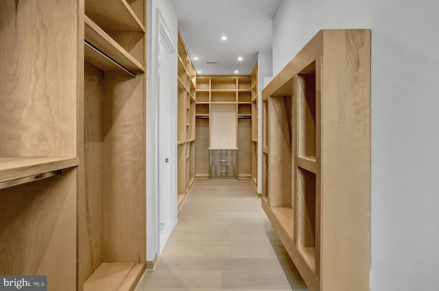 walk in closet with light wood-style floors