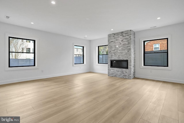 unfurnished living room featuring light wood-style floors, a fireplace, baseboards, and recessed lighting