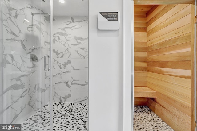 bathroom featuring wooden walls, a marble finish shower, and recessed lighting