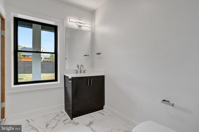 half bath with marble finish flooring, baseboards, vanity, and toilet
