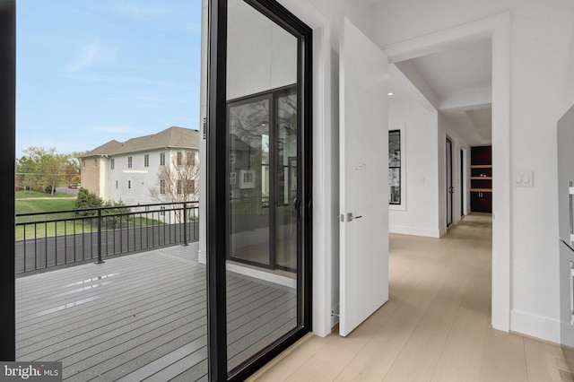 doorway to outside featuring wood finished floors and baseboards