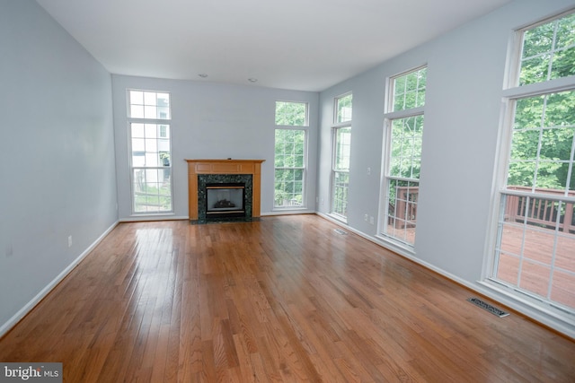 13076 Dove Tree Ct, Manassas, VA 20112 - unfurnished living room with wood finished floors, plenty of natural light, baseboards, and a premium fireplace