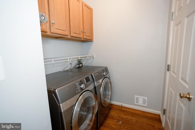13076 Dove Tree Ct, Manassas, VA 20112 - laundry area featuring separate washer and dryer, cabinet space, wood finished floors, and baseboards