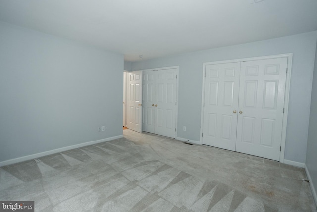 13076 Dove Tree Ct, Manassas, VA 20112 - unfurnished bedroom featuring two closets, carpet floors, and baseboards