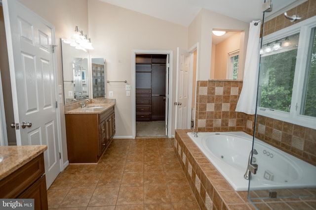 13076 Dove Tree Ct, Manassas, VA 20112 - bathroom featuring vanity, a jetted tub, vaulted ceiling, and tile patterned flooring