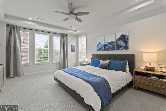 carpeted bedroom featuring a raised ceiling, baseboards, recessed lighting, and a ceiling fan