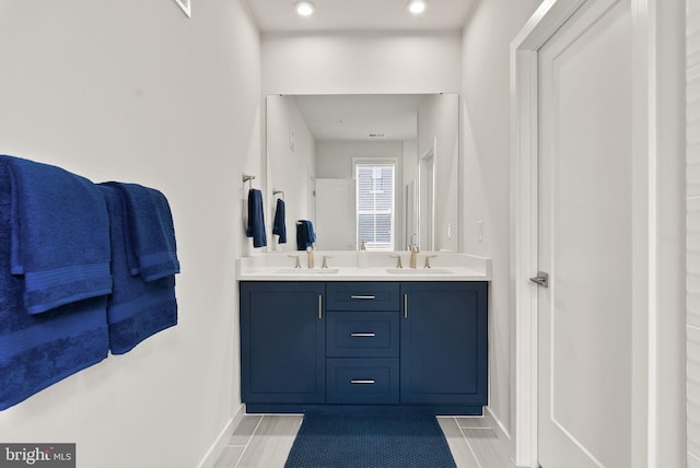 bathroom with double vanity and baseboards