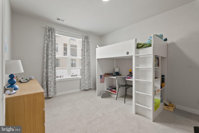 carpeted bedroom with an office area and baseboards
