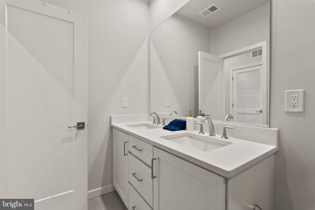 bathroom with baseboards and double vanity